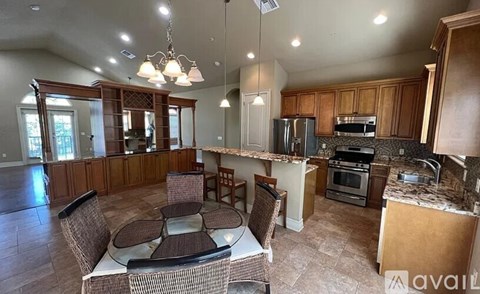 A kitchen with a table and chairs in the middle of the room.