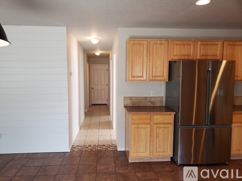 A kitchen with wooden cabinets and a stainless steel refrigerator.