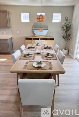 A dining room with a wooden table set for a meal.