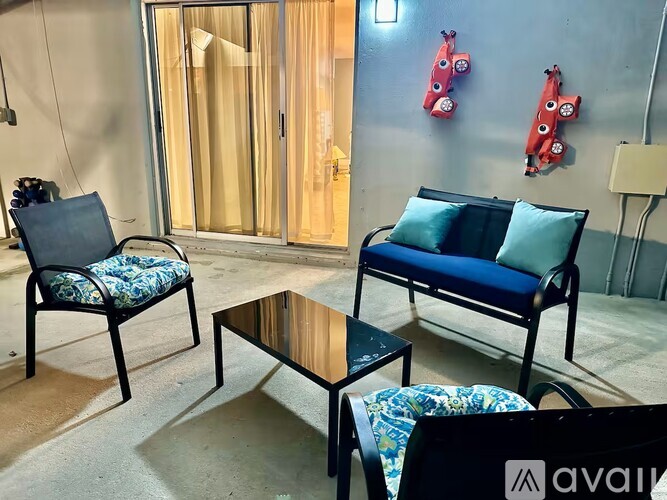 Three wicker chairs with floral cushions are placed on a patio.