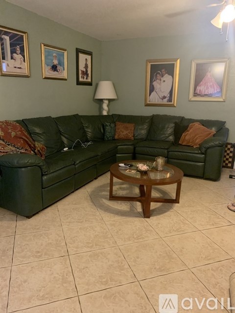 A living room with a green couch and a coffee table.