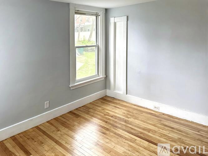 A room with wooden flooring and a window.