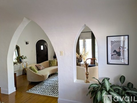 A living room with a couch and a plant.