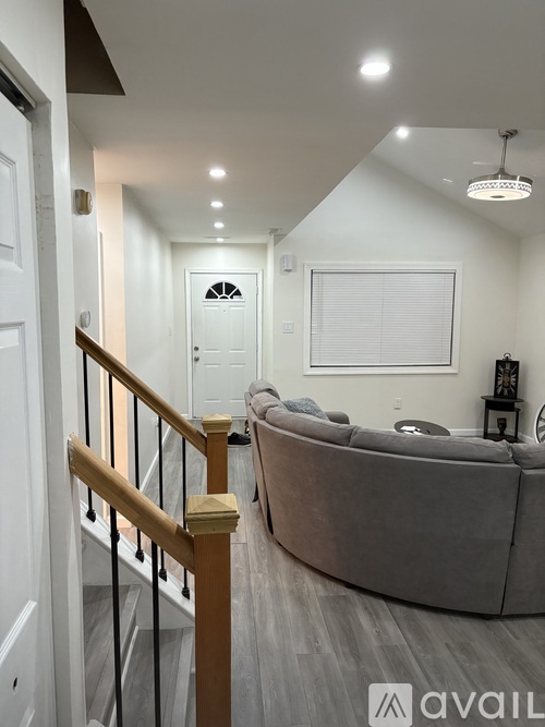 A living room with a couch and a staircase.