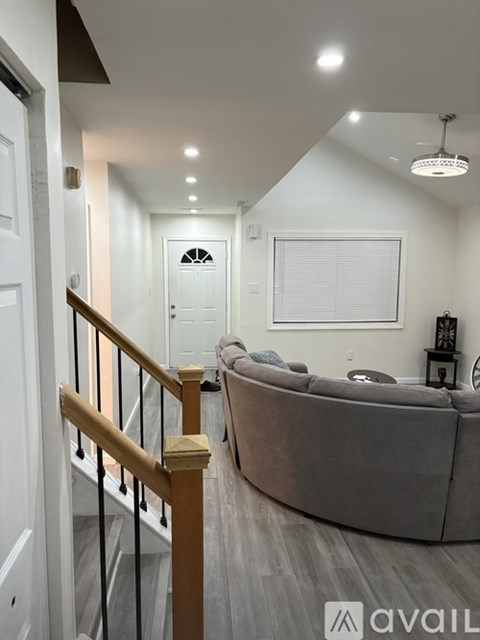 A living room with a couch and a staircase.