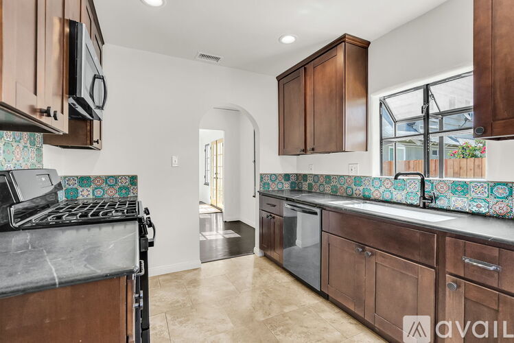 A kitchen with brown cabinets and a black stove top oven.