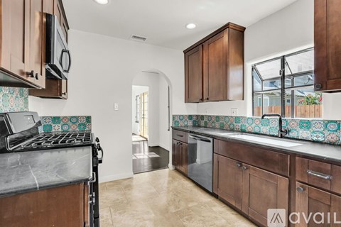 A kitchen with brown cabinets and a black stove top oven.