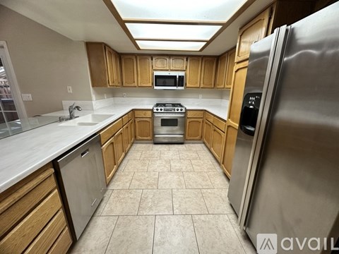 A kitchen with wooden cabinets and a stainless steel refrigerator.