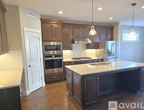 A kitchen with wooden cabinets and a white island.