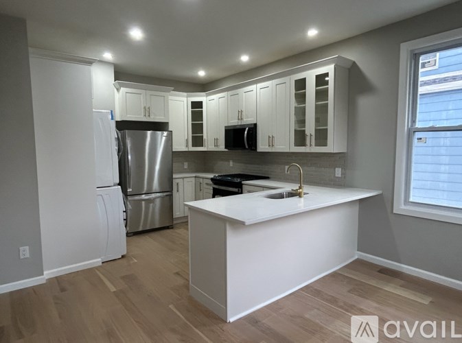 A kitchen with white cabinets and a white island.