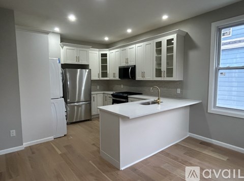 A kitchen with white cabinets and a white island.