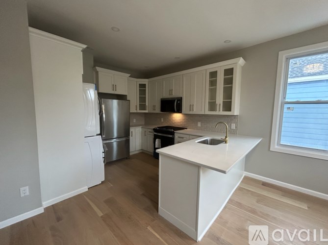 A kitchen with white cabinets and a white island.