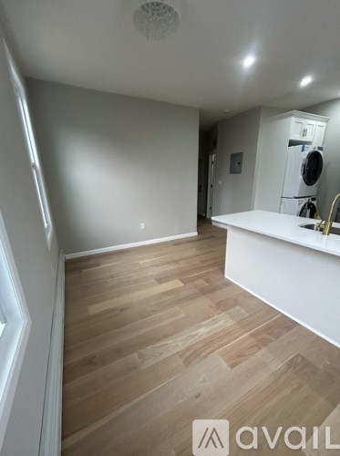 A room with wooden flooring and white walls.