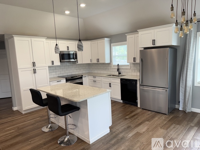 A modern kitchen with white cabinets and a central island.