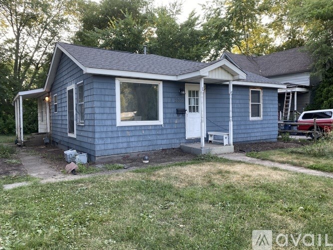 A blue house with a white door and windows.