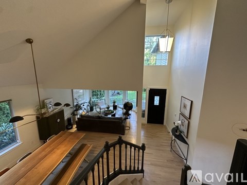 A living room with a wooden table and a black railing.