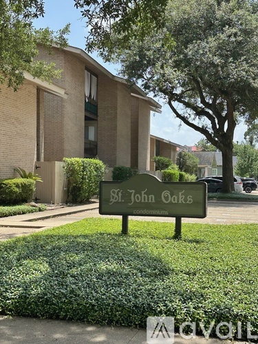 A sign for St. John Oaks Condominiums is in front of a building.