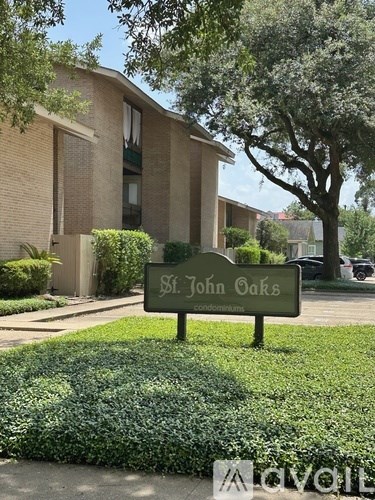 A sign for St. John Oaks Condominiums is in front of a building.