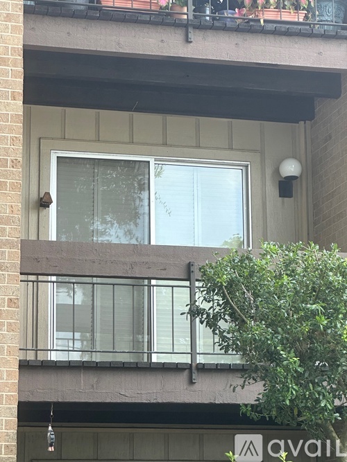 A balcony with a glass railing and a window.