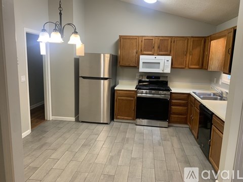 A kitchen with a refrigerator, oven, and microwave.