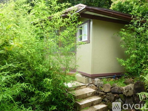 A small house is surrounded by greenery.