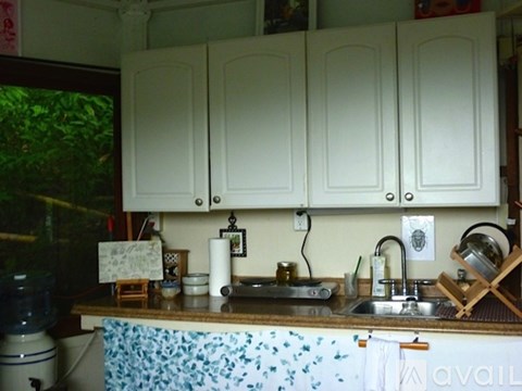 A kitchen with white cabinets and a blue floral counter.