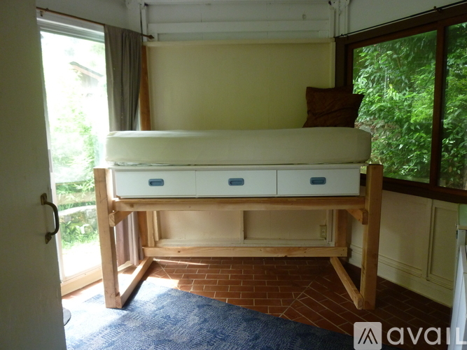 A bed with drawers underneath it in a room.