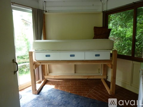 A bed with drawers underneath it in a room.