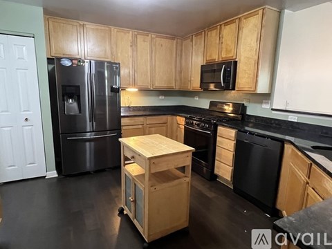 A kitchen with black appliances and wooden cabinets.