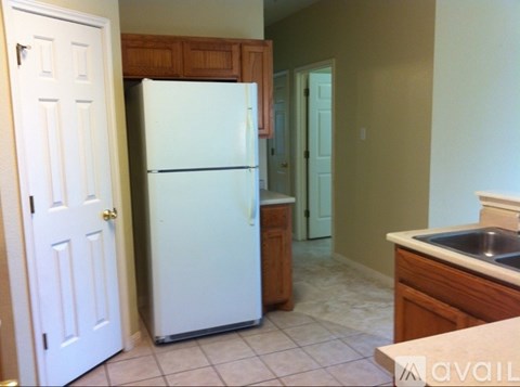 A white refrigerator in a kitchen with a white door and a white sink.