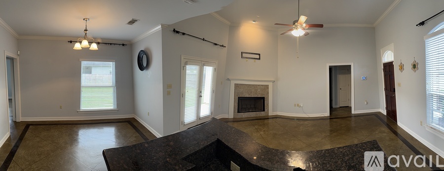 A large, empty living room with a fireplace and a marble countertop.
