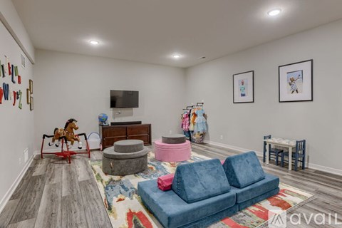 A living room with a blue couch and a rocking horse.