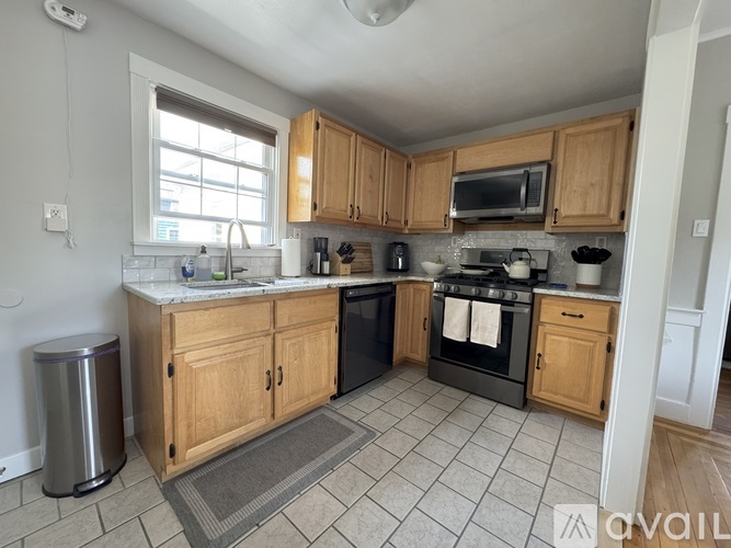 A kitchen with wooden cabinets and a tiled floor.