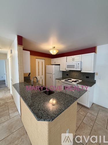 A kitchen with granite countertops and white appliances.