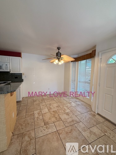 A room with a ceiling fan and a tiled floor.