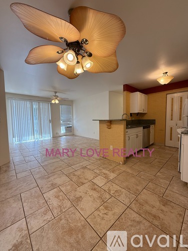 A room with a ceiling fan and tiled flooring.