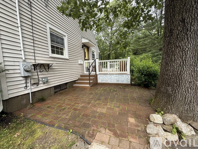 A house with a white fence and a brick patio.