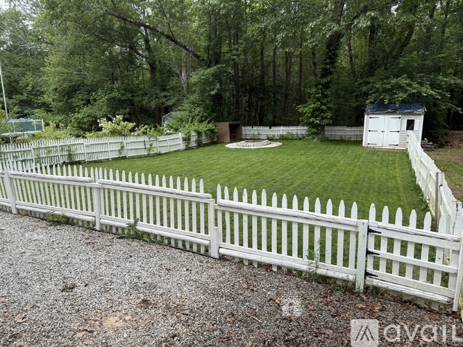 A white picket fence surrounds a green yard.