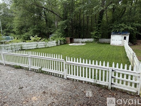 A white picket fence surrounds a green yard.