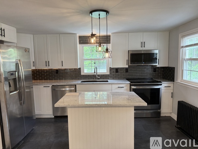 A kitchen with white cabinets and a central island.