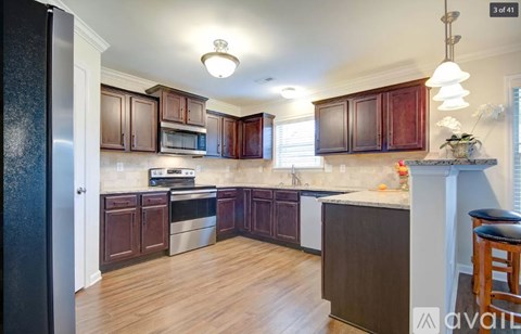A kitchen with wooden cabinets and a black refrigerator.