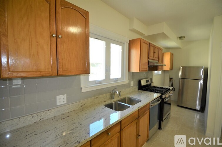 A kitchen with wooden cabinets and granite countertops.