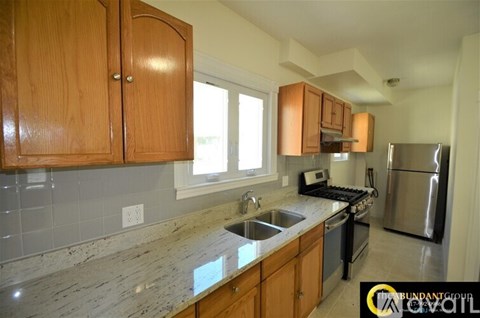 A kitchen with wooden cabinets and granite countertops.