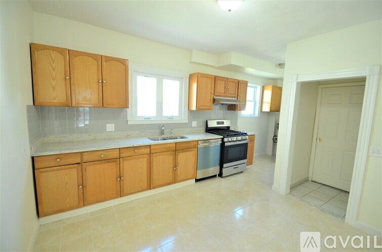 A kitchen with wooden cabinets and a tiled backsplash.