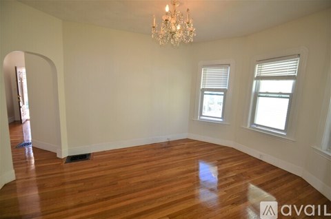 A room with wooden floors and a chandelier.