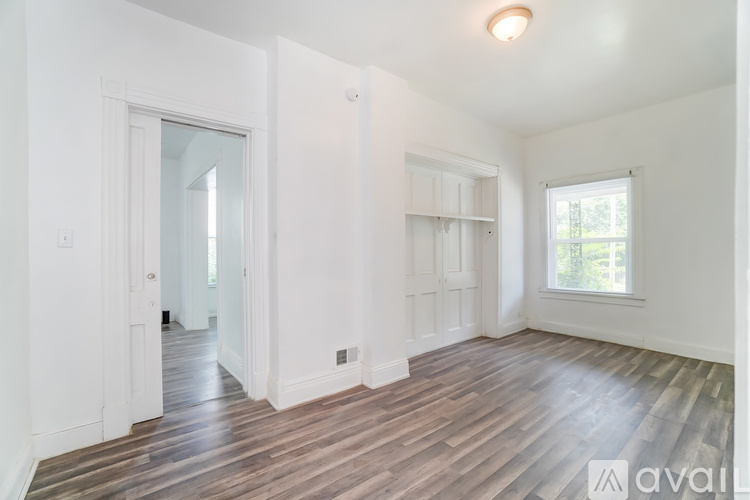 A spacious room with wooden floors and white walls.