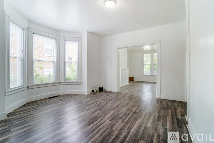A room with wooden floors and white walls is available for rent.