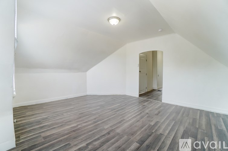 A room with wooden flooring and a white ceiling.