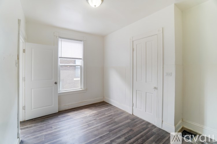 A room with a window and wooden floors.