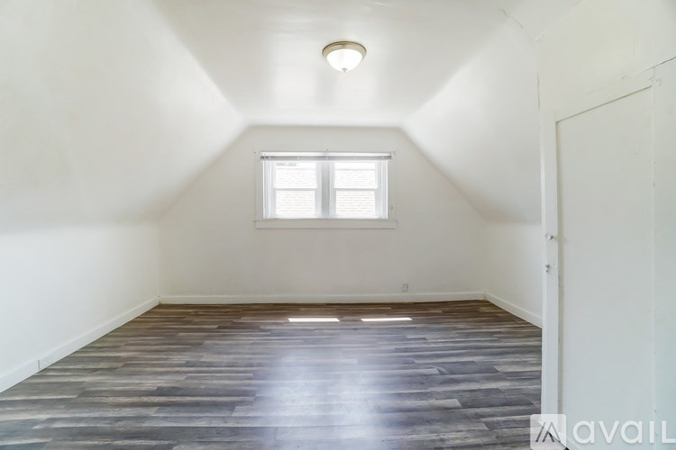 A room with a window and wooden flooring.